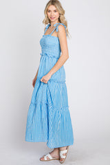 woman wearing a blue and white gingham tiered maxi dress with tie straps and smocked bodice