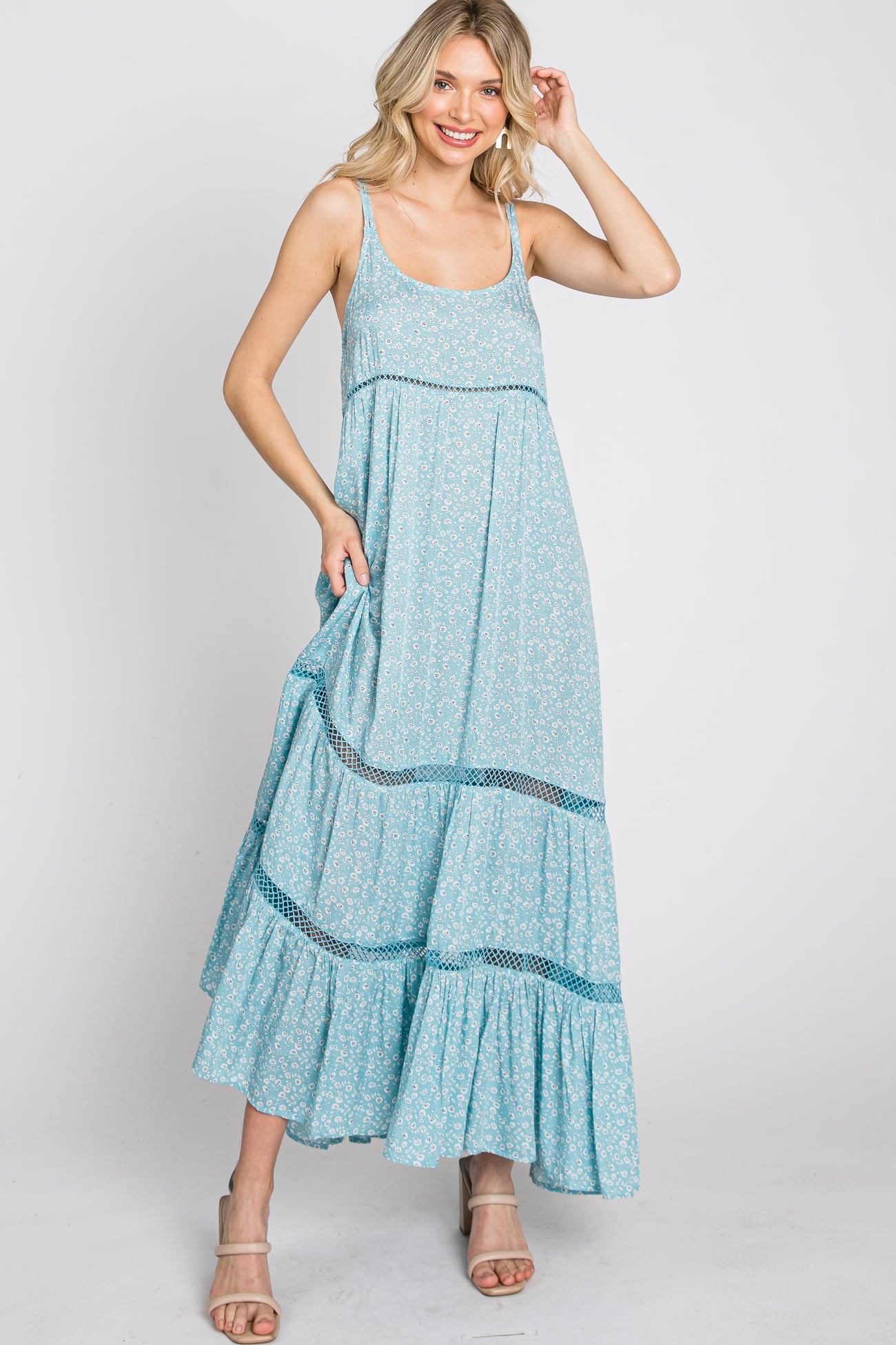 Woman wearing a light blue floral maxi dress with tiered skirt and crochet lace trim details