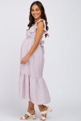 smiling pregnant woman wearing a lavender striped ruffle maternity midi dress and beige block heels