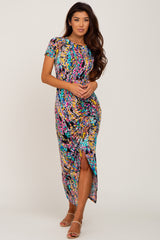 woman wearing a colorful abstract print short sleeve maxi dress with a side slit and tan heels