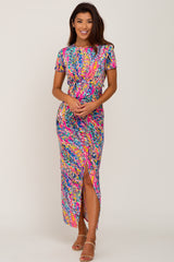 woman wearing a colorful tropical print maxi dress with a side slit and short sleeves