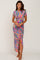 woman wearing a colorful tropical print maxi dress with a side slit and short sleeves