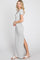 Woman wearing a grey short sleeve maxi dress with a side slit and ruched waist against a white background