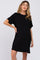 woman wearing a black short sleeve maternity t-shirt dress with a front pocket against a white background