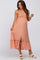 pregnant woman in peach button down maternity midi dress with ruffle trim and white block heel sandals