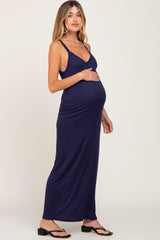 Pregnant woman wearing a navy blue ribbed maternity maxi dress with spaghetti straps and black sandals