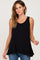 woman wearing a black sleeveless ruffle hem maternity tank top and blue jeans