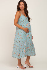 pregnant woman wearing a light blue floral maternity midi dress and white sandals