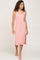 woman wearing a pink ribbed midi tank dress with a side slit and white flip flops