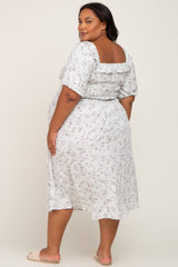 Plus size woman wearing a white floral smocked midi dress with puff sleeves and ruffle detail