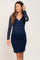 woman wearing a navy blue long sleeve lace maternity dress with a v-neckline
