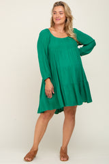 woman wearing a green tiered long sleeve maternity dress with a relaxed fit and sandals, showcasing a baby bump