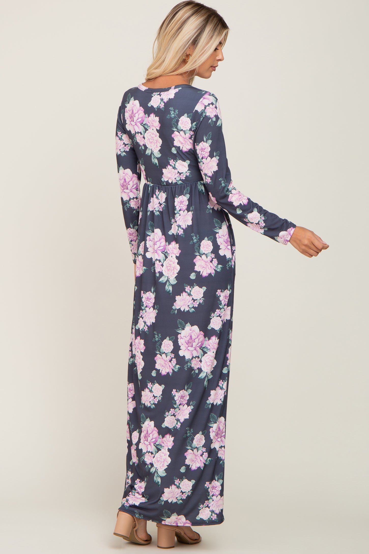 woman wearing a long sleeve navy blue floral maxi dress with pink and purple flowers