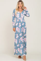 Woman wearing a long sleeve blue floral maxi dress with pink roses and button front detail