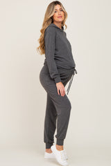 Pregnant woman wearing a charcoal grey maternity hoodie and jogger set with white sneakers