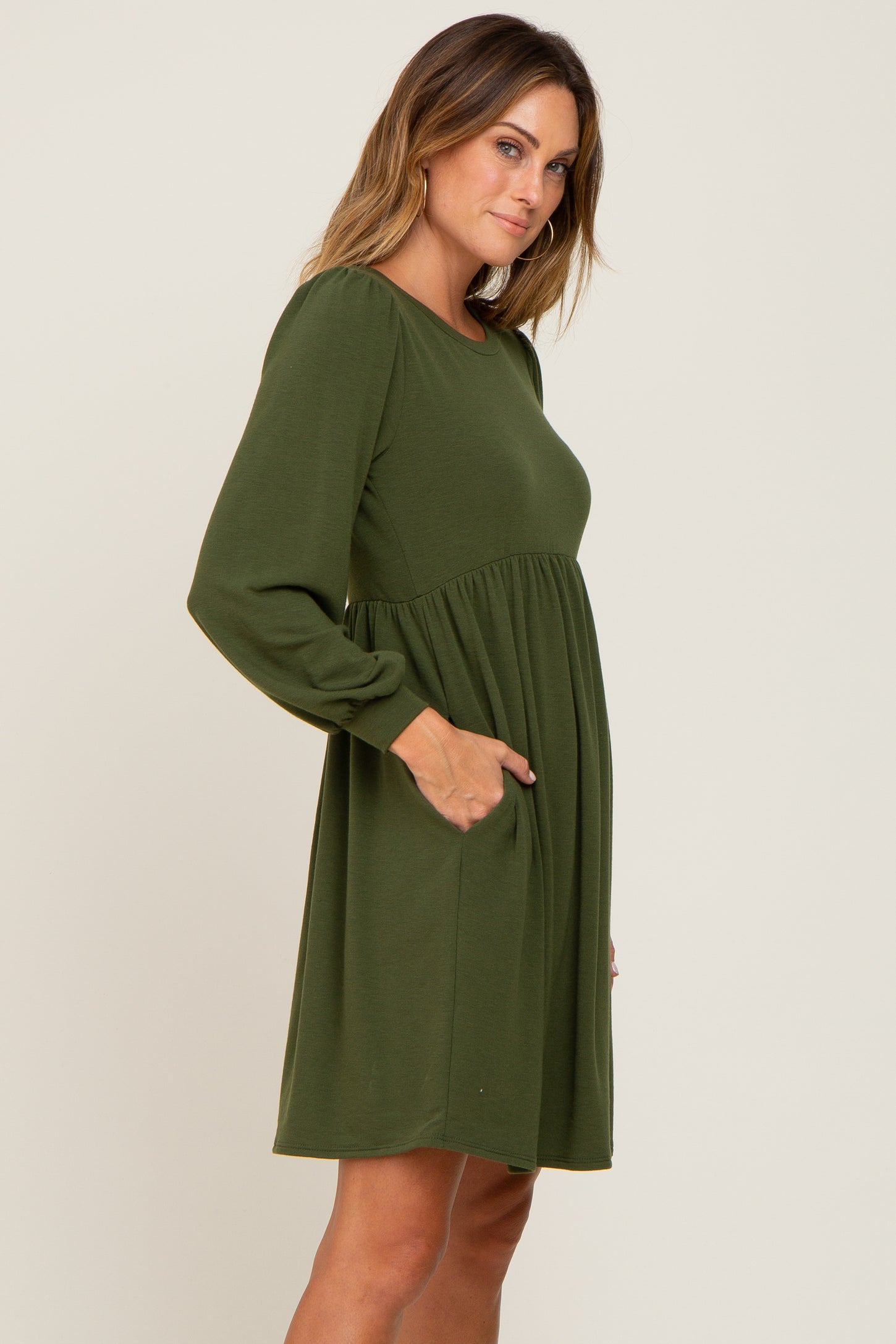woman wearing olive green long sleeve maternity dress with pockets and empire waist
