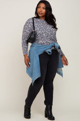 Plus size woman in floral long sleeve top, black jeans, and denim jacket tied around waist