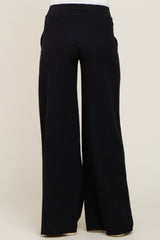 back view of person wearing black wide leg lounge pants with elastic waistband and raw hem