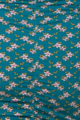 maternity wear in teal with a floral print featuring pink and yellow flowers, showing gathered detailing on the fabric