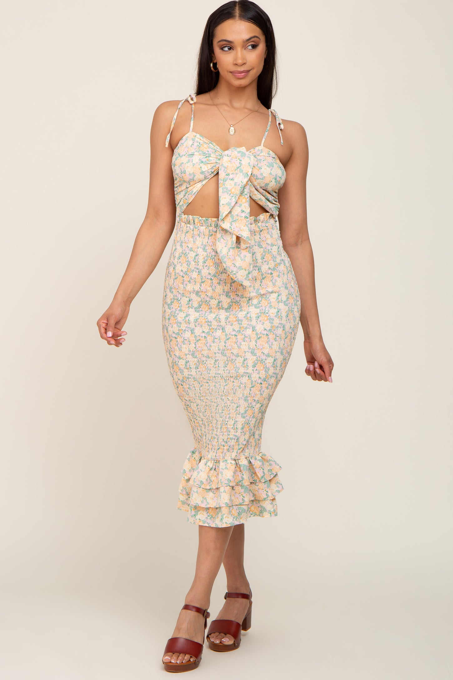 woman wearing a floral smocked midi dress with a cutout tie front and ruffled hem