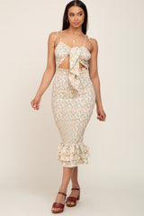 woman wearing a floral smocked midi dress with a cutout tie front and ruffled hem