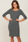 woman wearing a charcoal grey ribbed knit maternity dress with three-quarter sleeves