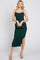 woman in emerald green ruched midi dress holding a black quilted clutch bag