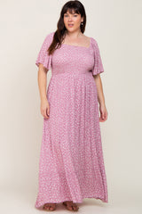 Woman wearing a pink floral smocked maxi dress with flutter sleeves and a square neckline