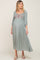 pregnant woman wearing a sage green maternity midi dress with floral embroidery and three-quarter sleeves