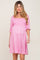 pregnant woman wearing a pink floral smocked maternity dress with puff sleeves