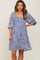 woman wearing a dusty blue floral maternity dress with square neckline and puff sleeves