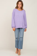 woman wearing a lavender ribbed long sleeve top and distressed light wash jeans with tan sandals