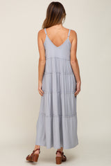 back view of woman wearing light blue tiered maxi dress with spaghetti straps and brown platform sandals