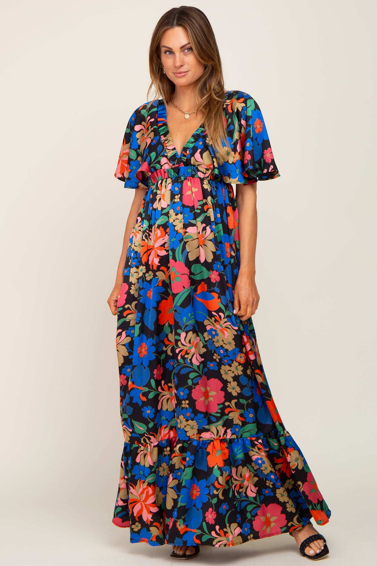 woman wearing a black floral print maxi dress with short flutter sleeves and a v-neckline