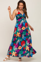woman wearing a colorful floral maxi maternity dress with a twist front detail and a visible baby bump