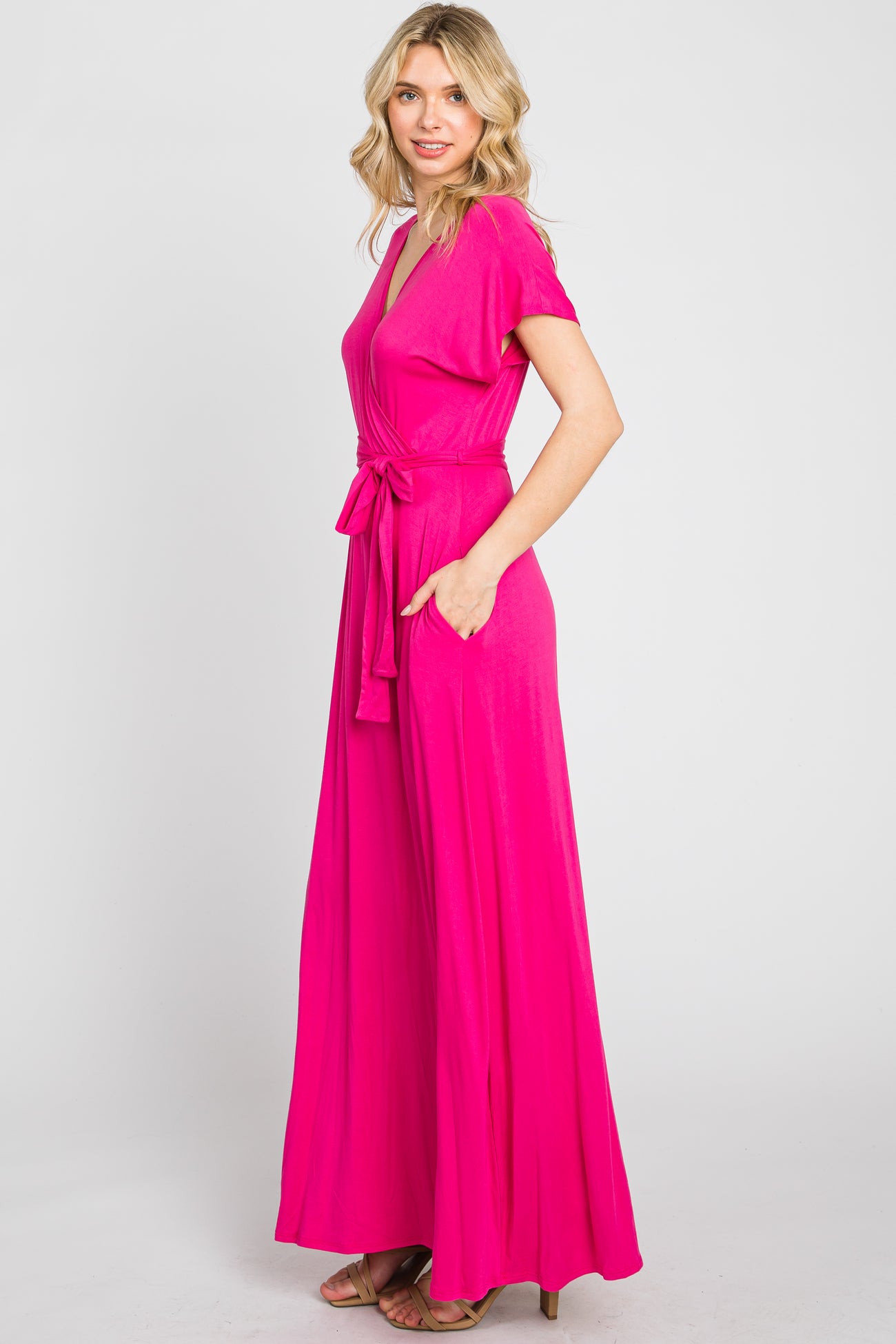 woman wearing a bright pink short sleeve maxi dress with a waist tie and pockets