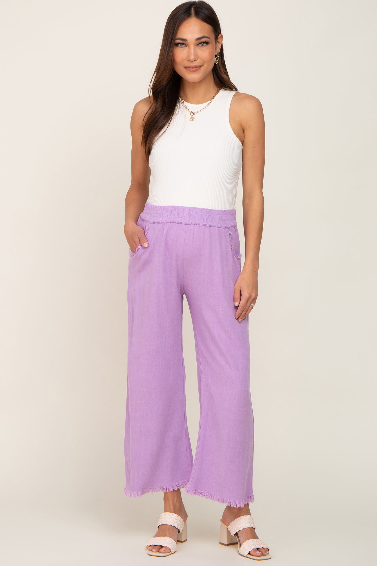 woman wearing white ribbed tank top and purple wide leg linen pants with frayed hem