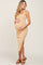 woman wearing a beige ribbed midi maternity dress with a side slit and holding her baby bump