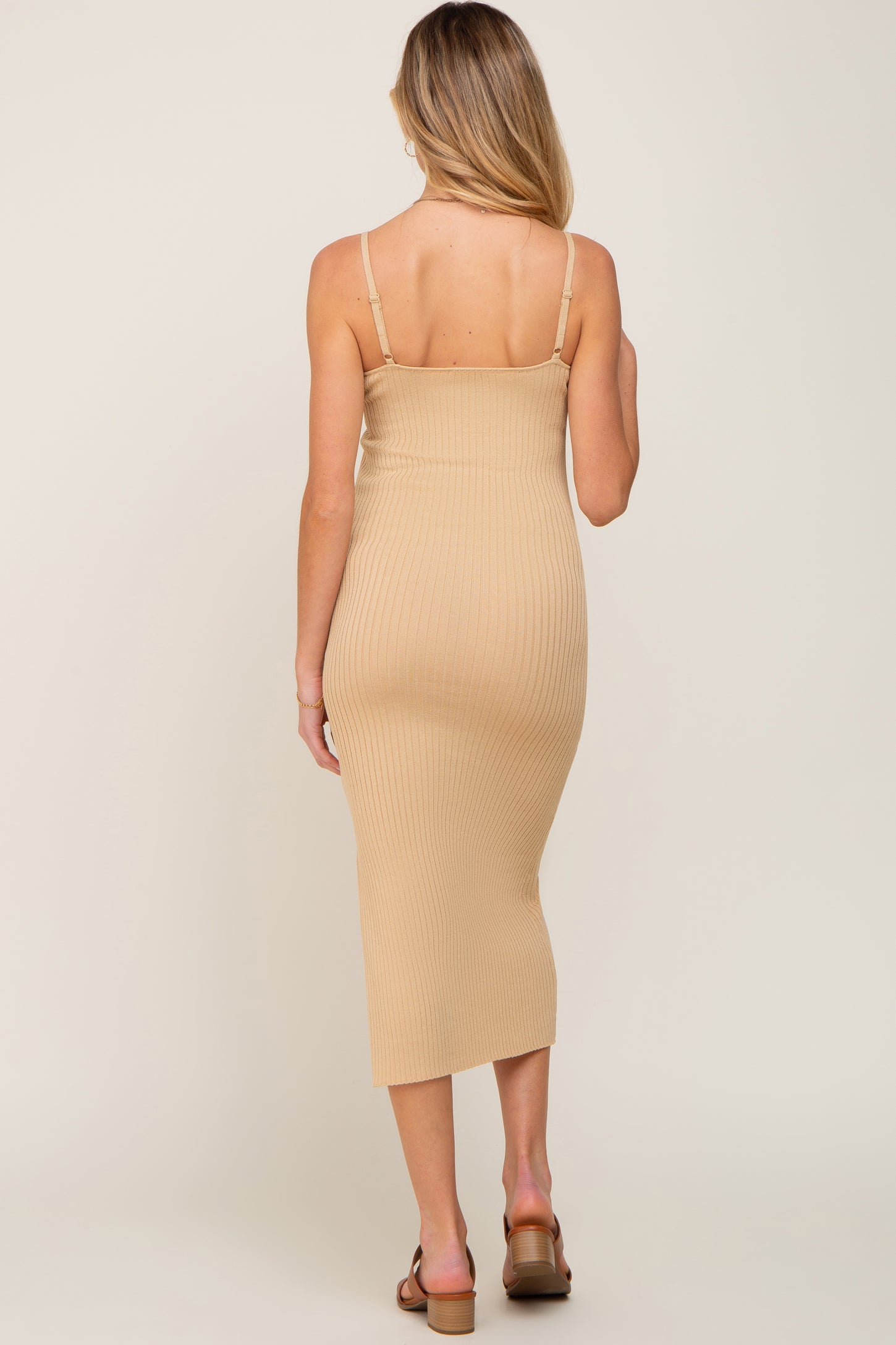 back view of a woman wearing a tan ribbed knit bodycon midi dress with spaghetti straps