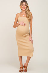 woman wearing a ribbed beige maternity dress and holding her baby bump