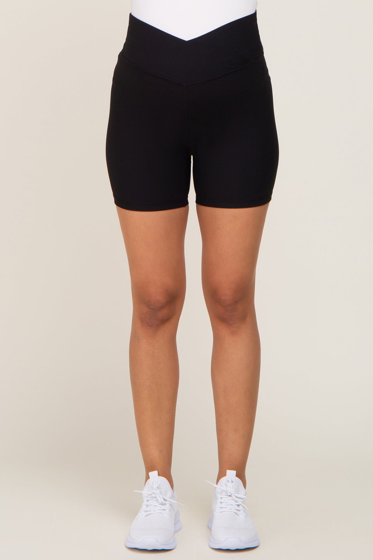 woman wearing black high-waisted ribbed biker shorts and white sneakers