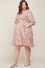 Pregnant woman in a floral smocked maternity dress with pockets and white block heel sandals