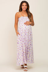 Pregnant woman wearing a purple floral smocked maternity maxi dress with spaghetti straps