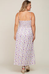 Back view of a woman wearing a purple and yellow floral smocked maxi dress with spaghetti straps and wedge sandals