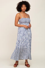 woman wearing a blue and white paisley print smocked maxi dress with spaghetti straps and button front