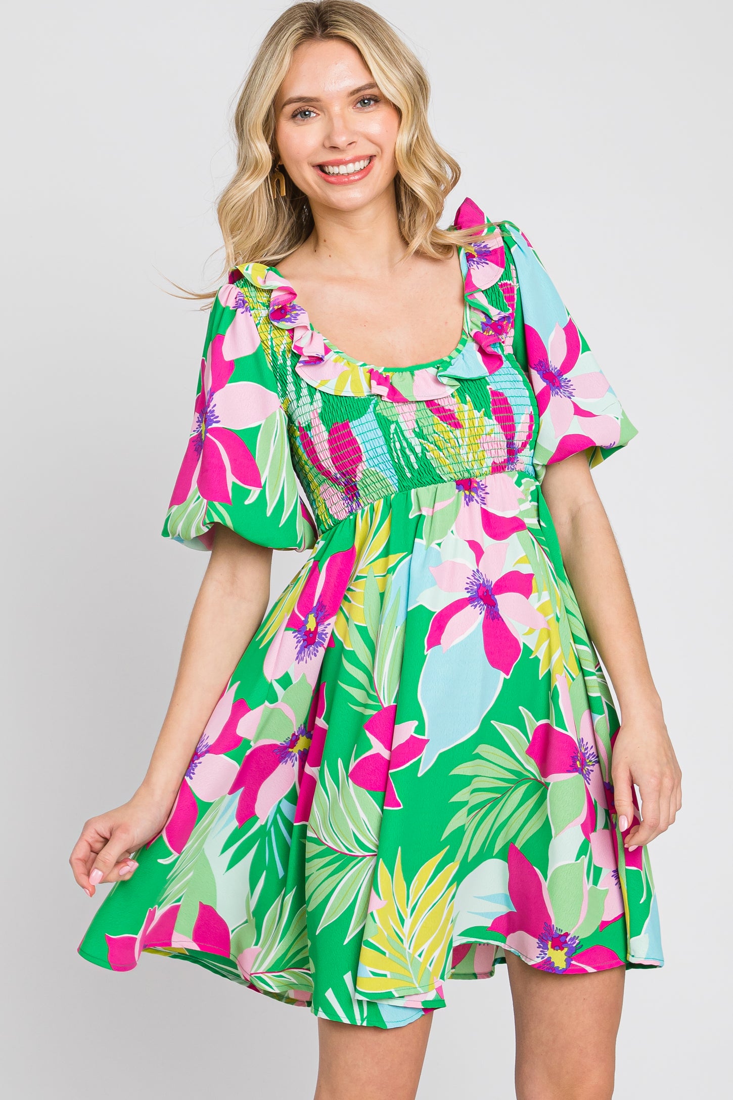 woman wearing a colorful floral print short dress with ruffled sleeves and a fitted bodice