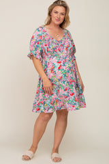 woman wearing a colorful floral print maternity dress with smocked bodice and short puff sleeves