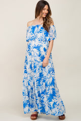 woman wearing a blue floral off-the-shoulder maternity maxi dress and showing her baby bump
