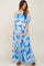 woman wearing a blue floral off-the-shoulder maternity maxi dress and showing her baby bump