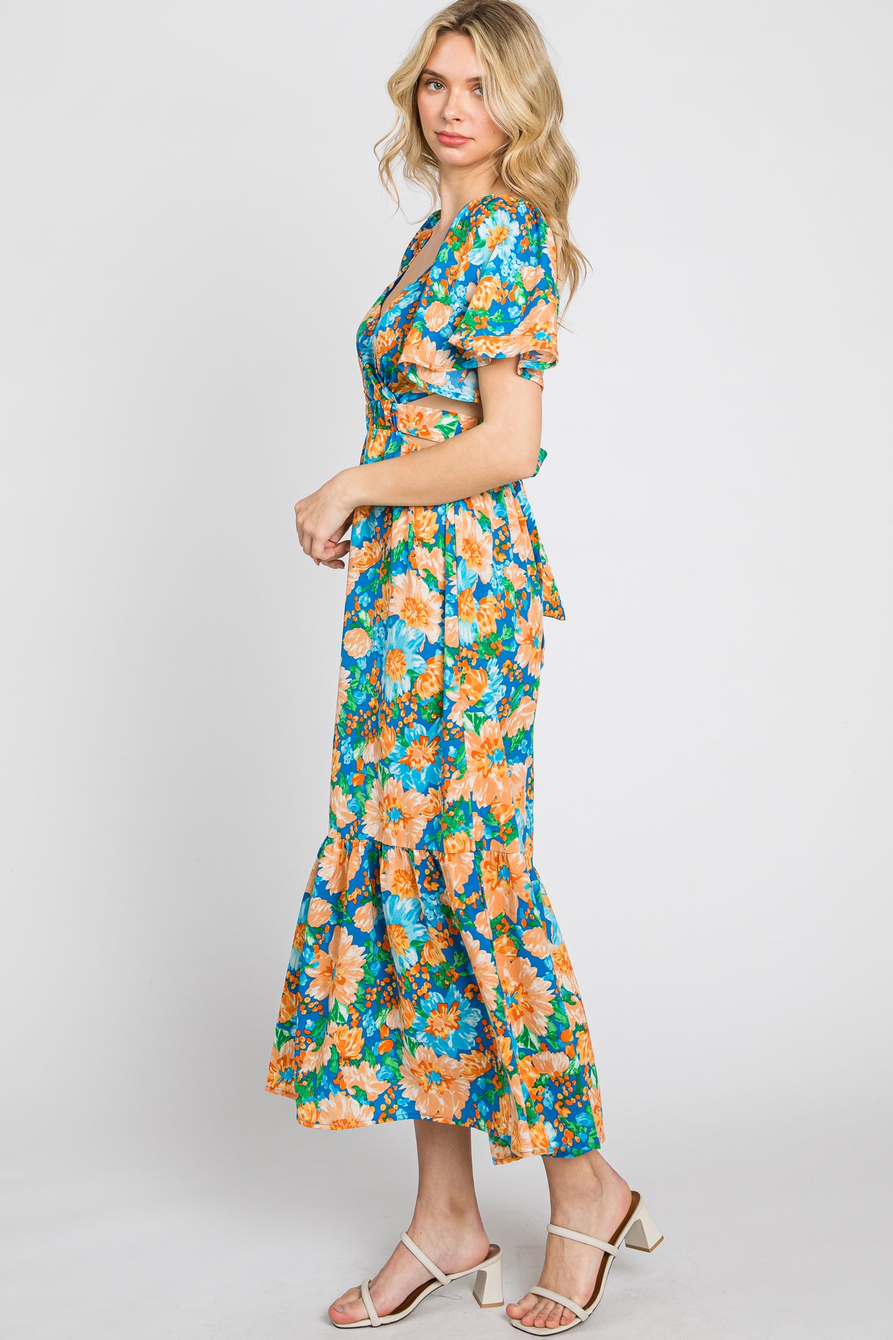 woman wearing a floral print blue maxi dress with short puff sleeves and a tiered hemline
